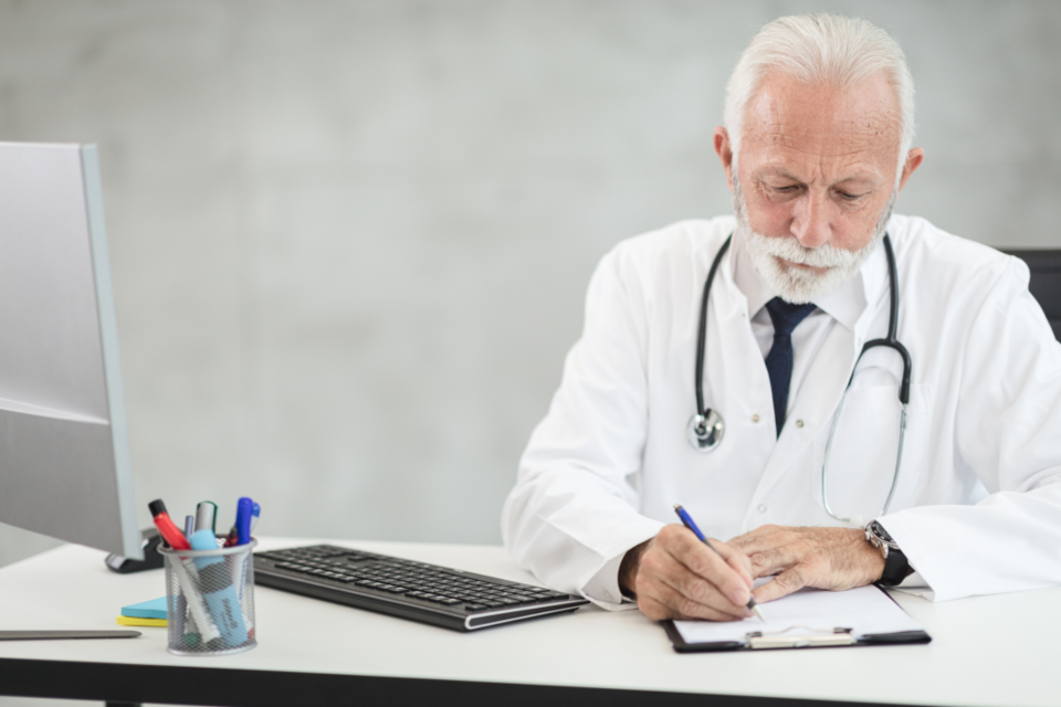 Doctor reviewing paperwork at a desk