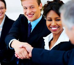 Two business people shaking hands over paperwork